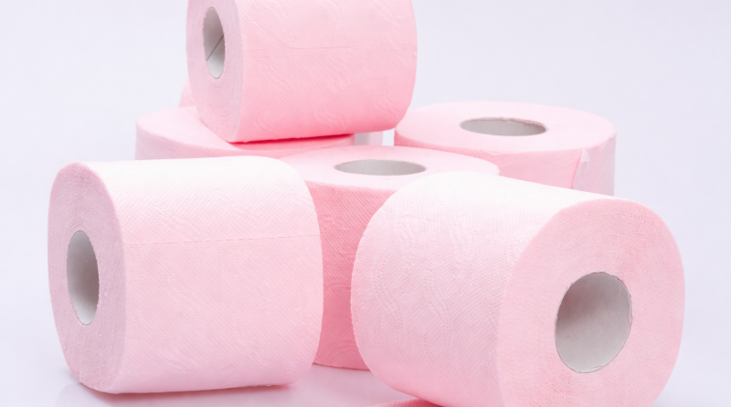 Rouleaux de papier toilette roses empilés sur un fond blanc, illustrant un produit d’hygiène du quotidien et la consommation domestique.