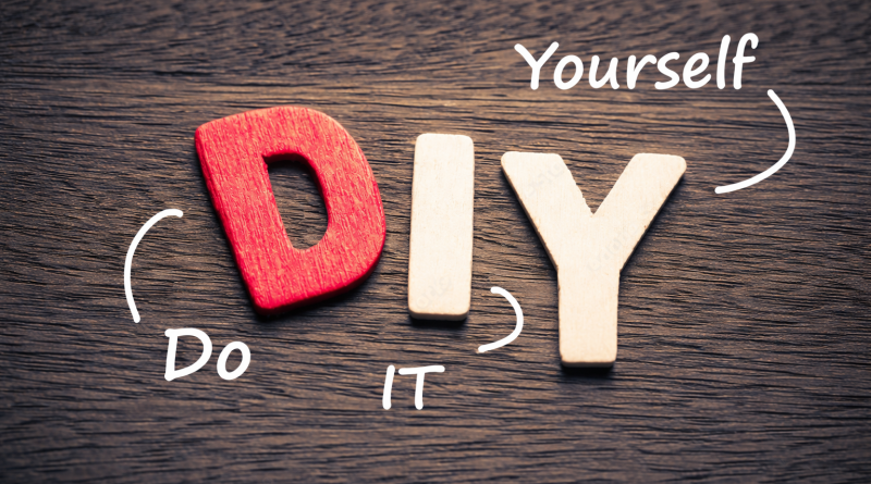 Lettres en bois formant le mot DIY posées sur une surface en bois sombre, illustrant le principe du fait maison et de la création par soi-même.