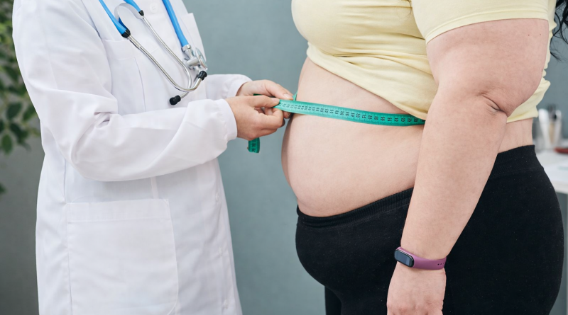 professionnel de santé mesurant le tour de taille d’une personne en situation de surpoids avec un mètre ruban