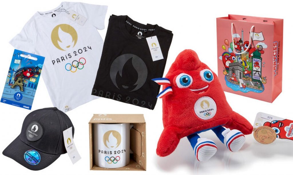 Ensemble de produits dérivés sportifs disposés sur fond clair, comprenant des vêtements, une peluche, des accessoires et un sac, aux couleurs rouge, blanc et bleu.
