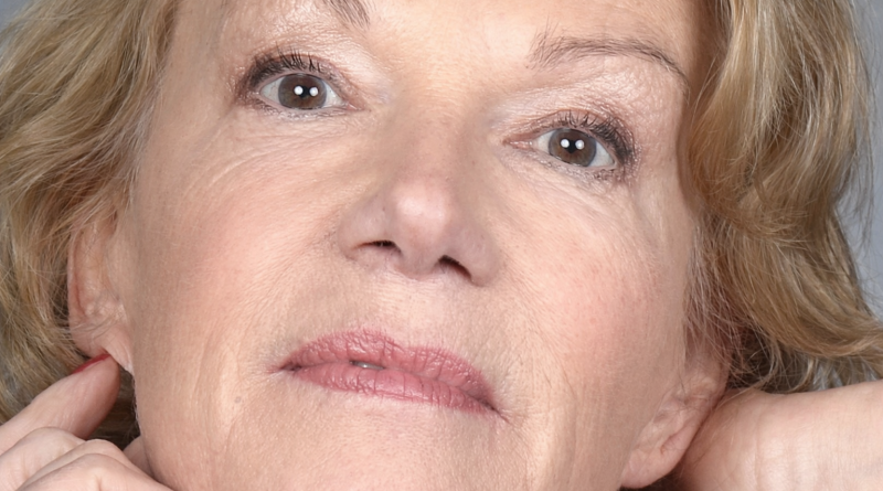 portrait en gros plan d’une femme mature regardant l’objectif, expression neutre, éclairage doux, fond clair