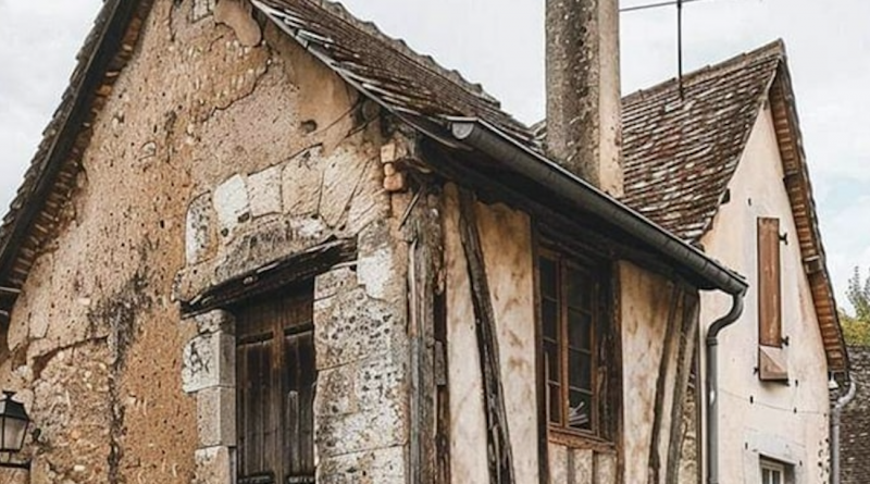 Maison médiévale à colombages avec encorbellement, murs en pierre et torchis, toiture ancienne et cheminée massive, architecture ancienne préservée