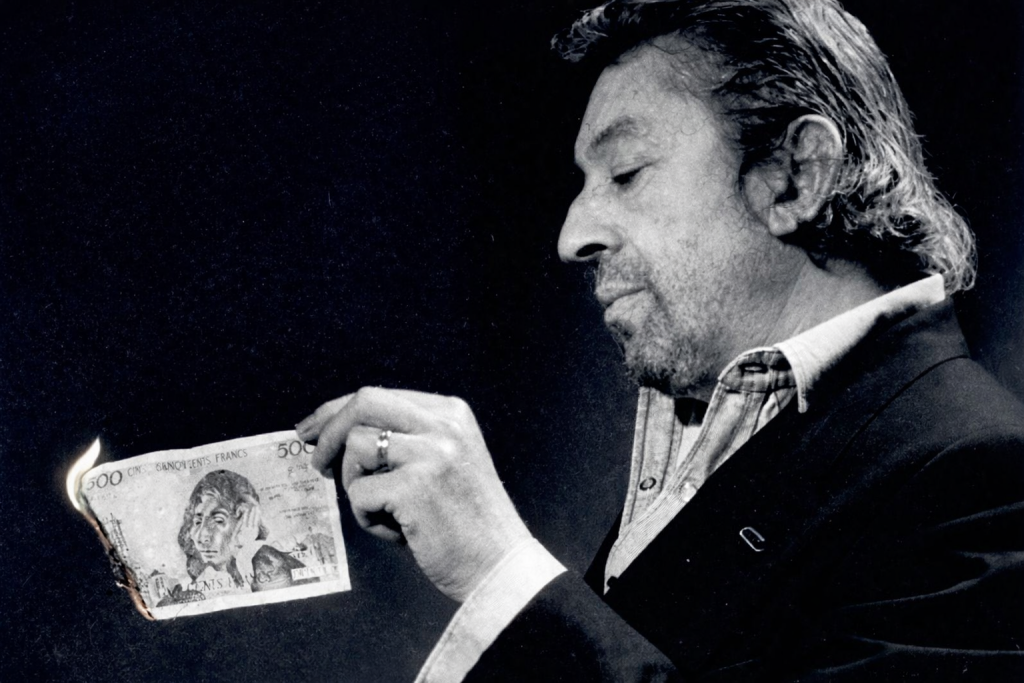 Homme tenant un billet de banque en feu, scène symbolique illustrant la provocation, l’argent et la transgression culturelle.