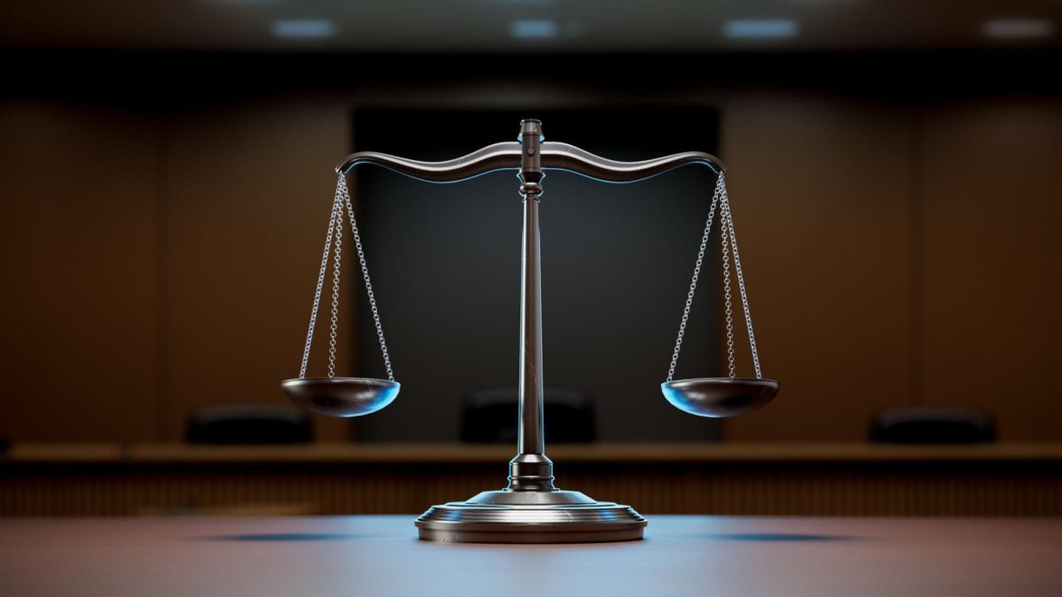 balance de justice métallique posée sur une table dans une salle de tribunal avec un arrière-plan flou et sombre symbolisant l’équité, l’impartialité et les décisions judiciaires en France