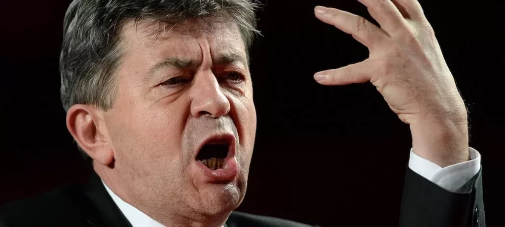 Homme politique en colère s’exprimant avec véhémence, bouche ouverte et geste brusque de la main, dans une ambiance solennelle évoquant un débat tendu