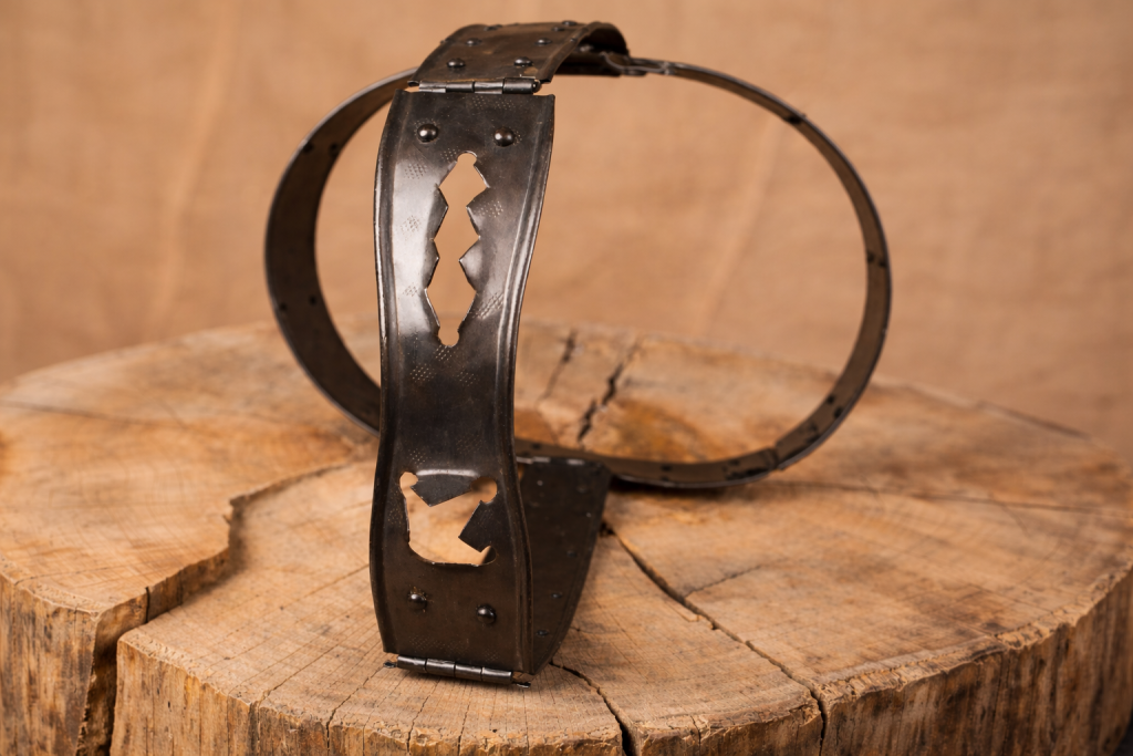 ceinture de chasteté en métal ancien posée sur une surface en bois
