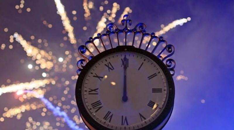 Horloge ancienne indiquant minuit avec des feux d’artifice éclatant dans le ciel nocturne, symbole du passage à la nouvelle année et du 1er janvier