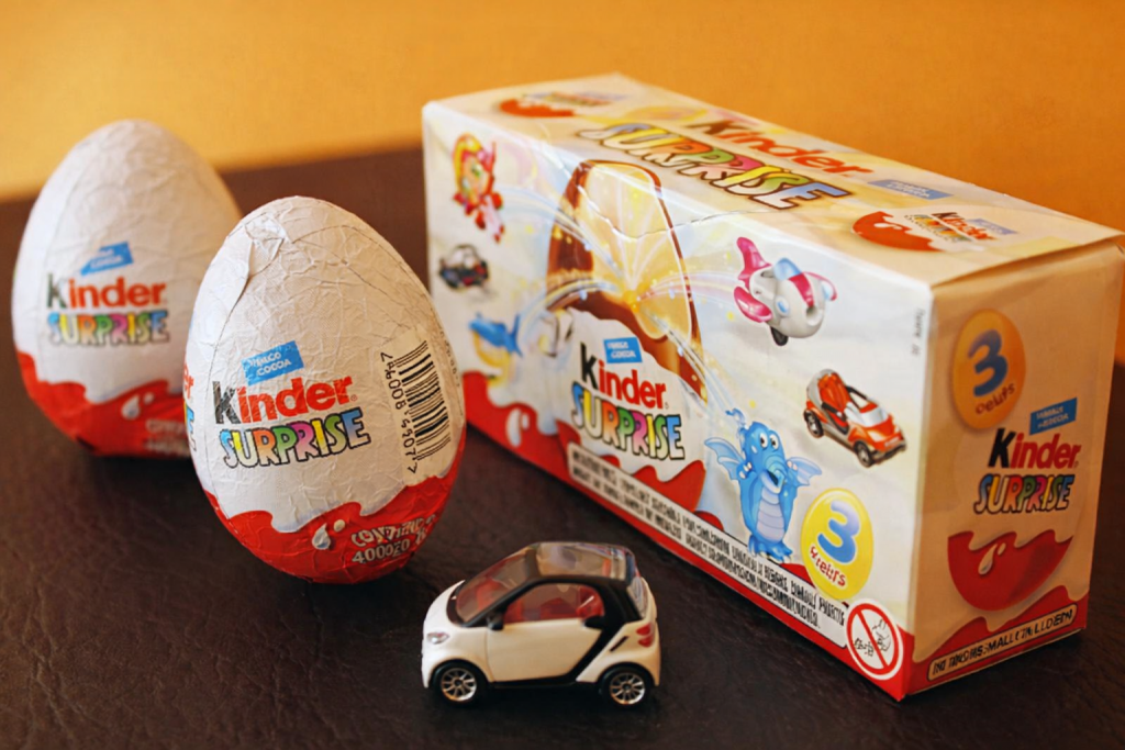 œufs en chocolat emballés avec un petit jouet miniature posés sur une table