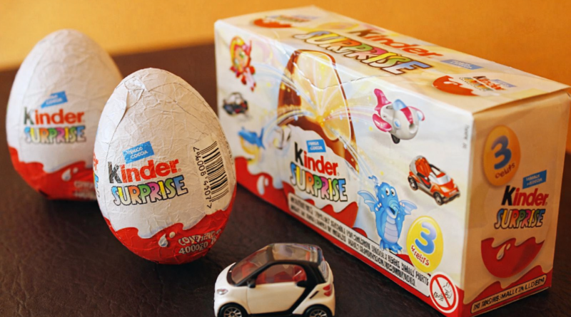 œufs en chocolat emballés avec un petit jouet miniature posés sur une table