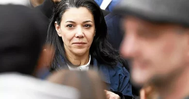 Femme au visage sérieux au milieu d’une foule, regard fixé droit devant lors d’un rassemblement politique