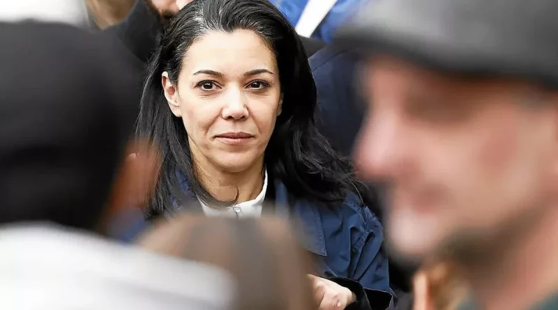 Femme au visage sérieux au milieu d’une foule, regard fixé droit devant lors d’un rassemblement politique