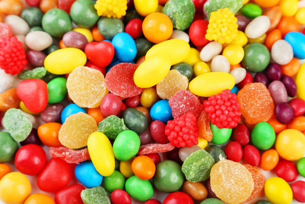 Assortiment de bonbons colorés aux formes variées, textures lisses et sucrées, vus en gros plan, évoquant une confiserie multicolore sans référence à une marque.