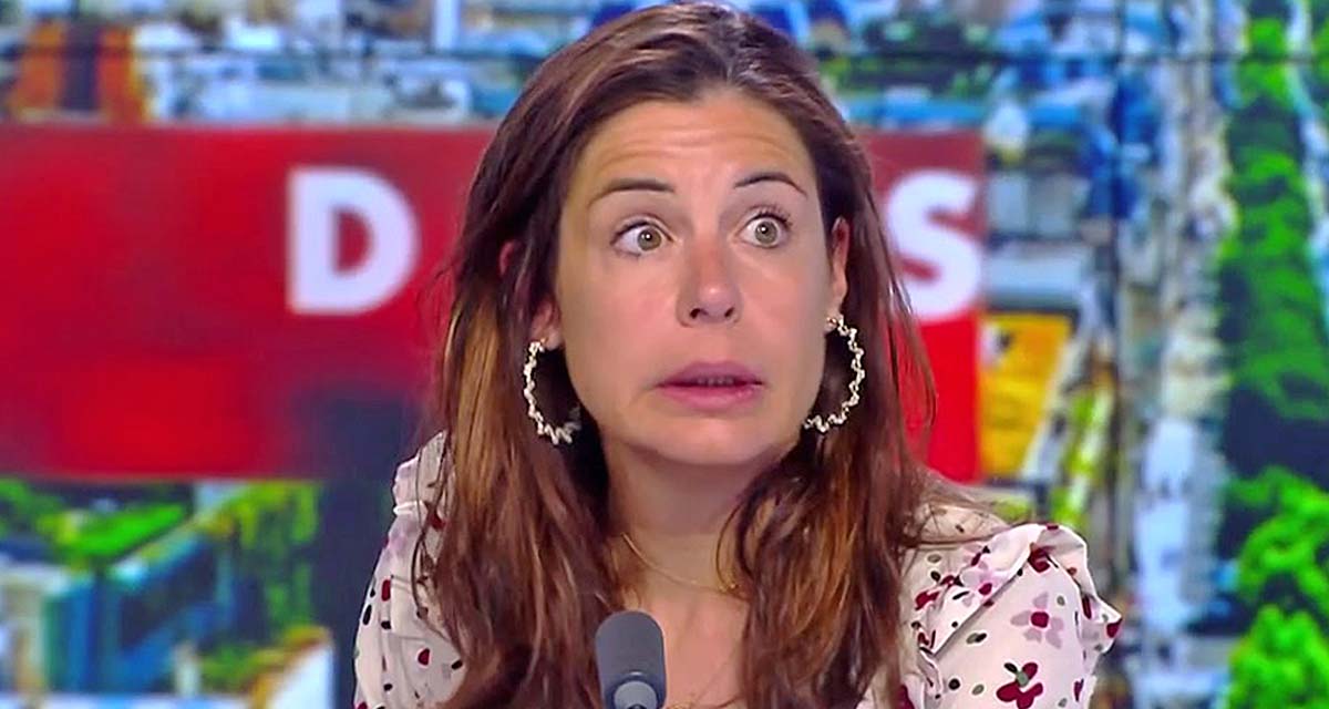 Femme brune visiblement émue et fatiguée, assise devant un micro sur un plateau de télévision coloré, fixant la caméra avec une expression de surprise et de lassitude.