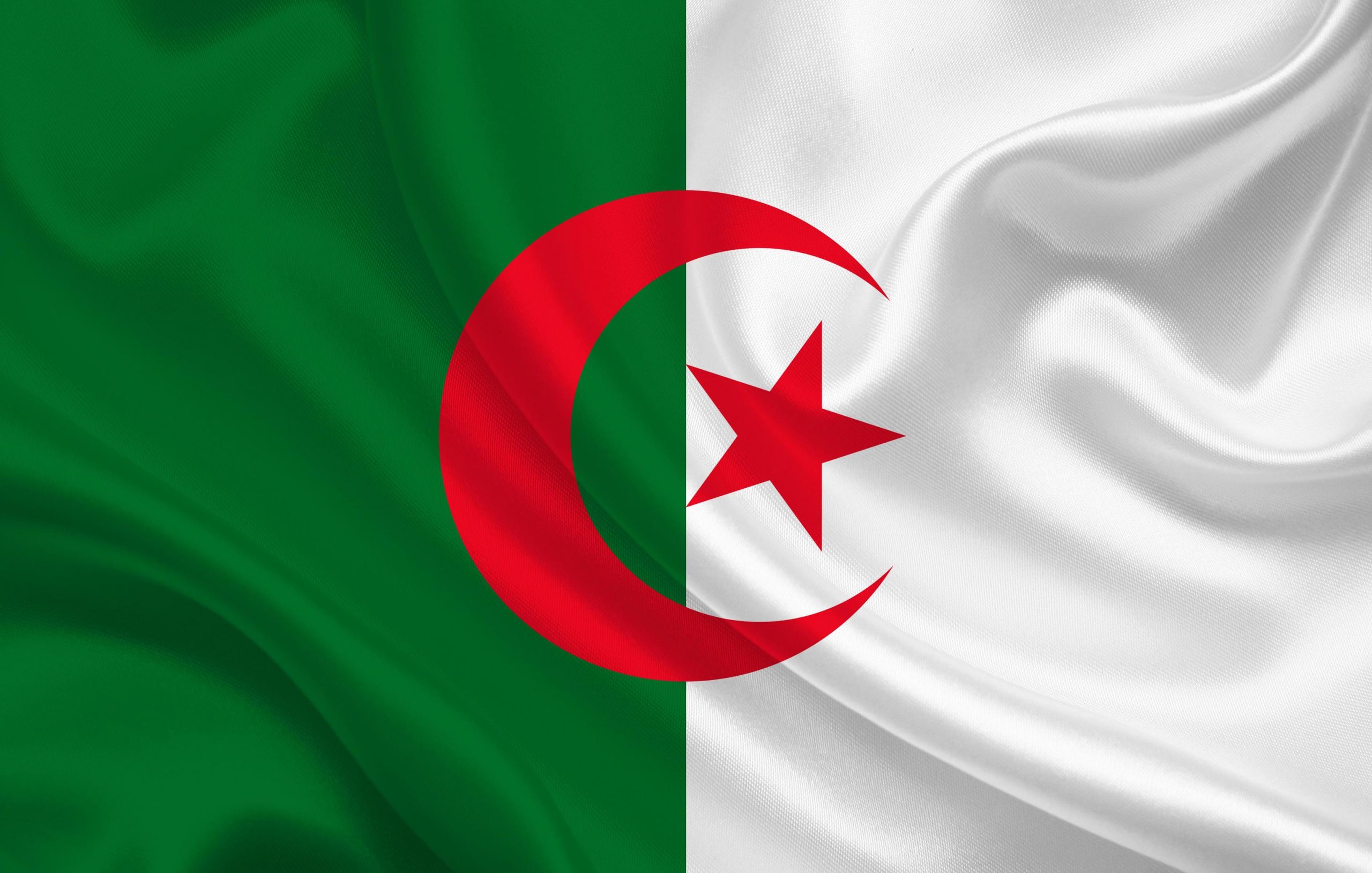 Drapeau algérien en gros plan, symbole du Maghreb, utilisé pour illustrer une enquête sur les pensions de retraite françaises versées à l’étranger.
