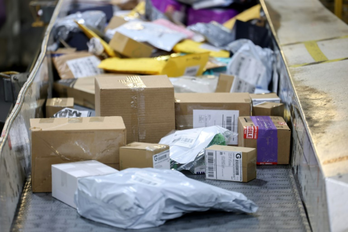Colis et paquets de différentes tailles circulant sur un tapis de tri dans un centre logistique, illustrant le volume élevé des envois internationaux à bas coût.
