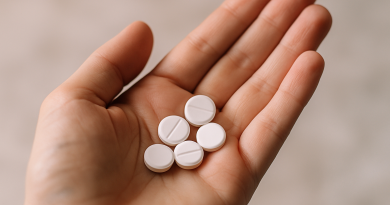 gros plan de comprimés psychotropes posés dans une main ouverte, arrière-plan flou doux