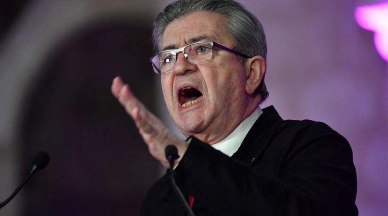 Un homme âgé parlant avec intensité devant un micro, la main levée dans un geste expressif, lors d’une prise de parole publique.