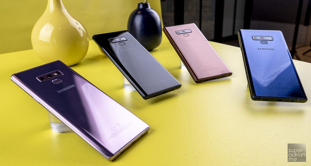 Plusieurs smartphones modernes alignés sur une table colorée, vus de dos, montrant différents designs et finitions.