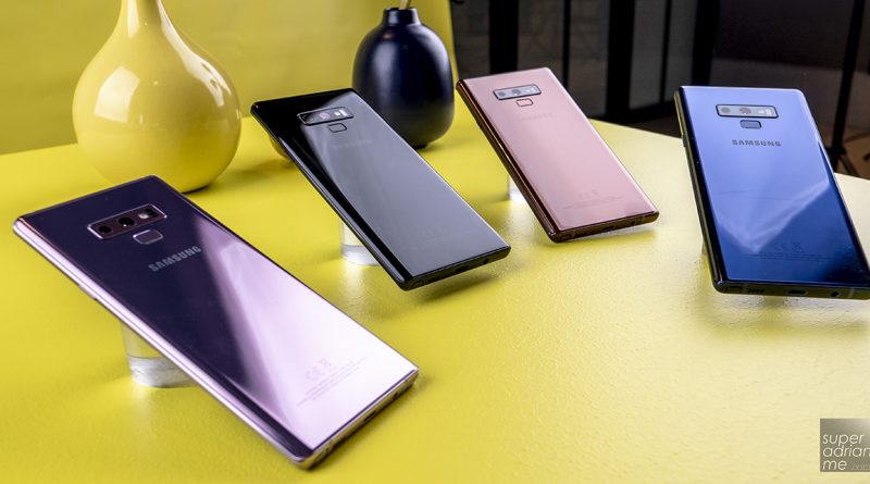 Plusieurs smartphones modernes alignés sur une table colorée, vus de dos, montrant différents designs et finitions.