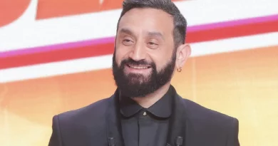 Animateur barbu souriant en costume sombre sur un plateau lumineux, évoquant une prise de parole médiatique et une confidence publique