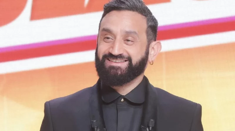 Animateur barbu souriant en costume sombre sur un plateau lumineux, évoquant une prise de parole médiatique et une confidence publique