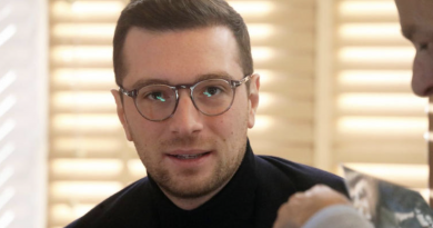 Jeune homme politique portant des lunettes, regard sérieux, en entretien dans un intérieur lumineux aux tons neutres