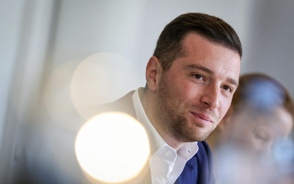 Portrait d’un homme souriant en intérieur, lumière douce, ambiance calme.
