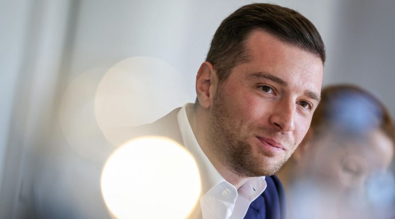 Portrait d’un homme souriant en intérieur, lumière douce, ambiance calme.