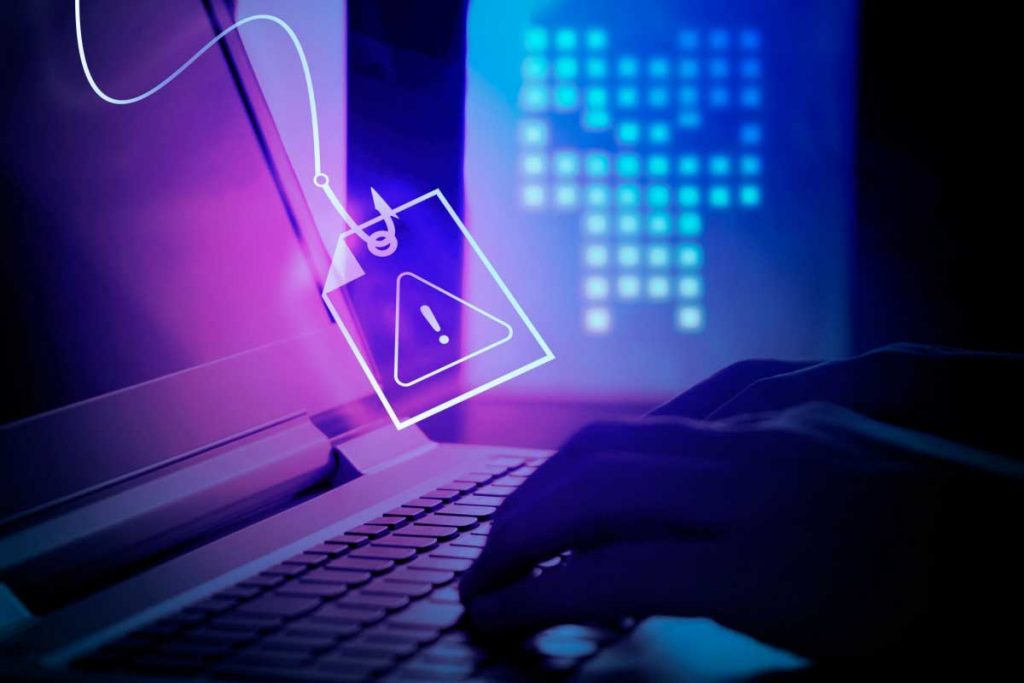 Ordinateur portable utilisé dans une ambiance sombre avec une icône d’alerte en forme d’étiquette suspendue, symbolisant une tentative de phishing et un risque de compromission des données personnelles