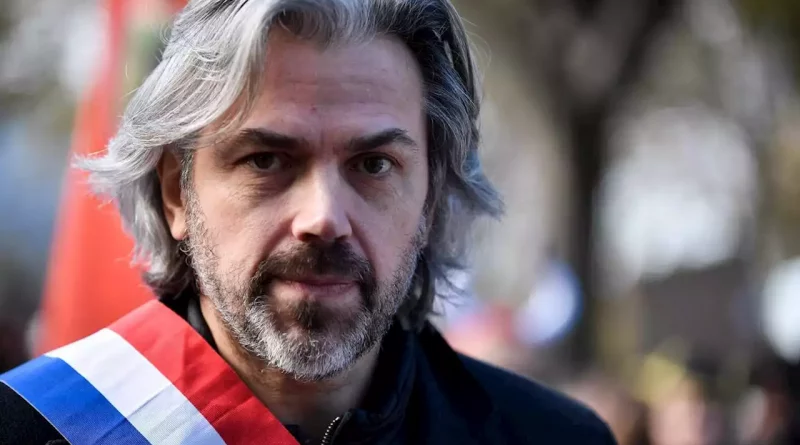 Portrait d’un élu portant une écharpe tricolore, debout en extérieur, regard dirigé vers l’objectif.