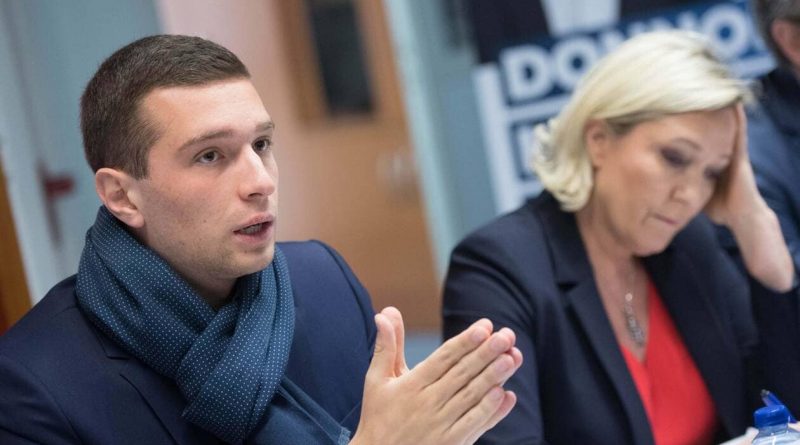 Deux personnes en réunion, l’une prenant la parole pendant que l’autre écoute, scène illustrant une discussion politique ou sociale.