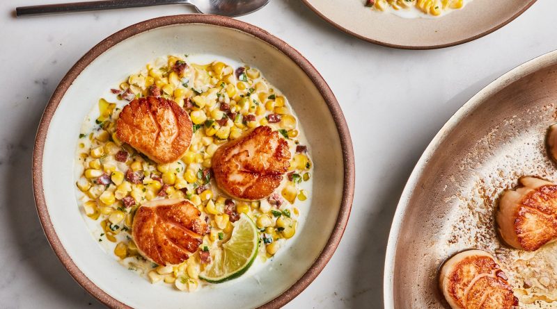Assiette de noix dorées déposées sur un mélange crémeux de maïs, vue rapprochée dans une ambiance culinaire chaleureuse.