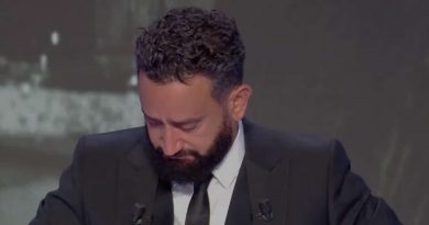 animateur de télévision ému, tête baissée, les yeux humides, costume sombre sur un plateau de talk-show