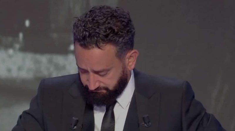 animateur de télévision ému, tête baissée, les yeux humides, costume sombre sur un plateau de talk-show