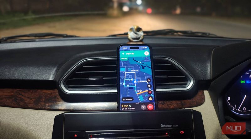 Smartphone affichant une carte de navigation, fixé sur le tableau de bord d’une voiture roulant de nuit.