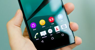 Smartphone moderne tenu dans une main affichant des applications sur un écran lumineux