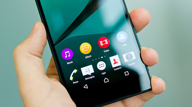 Smartphone moderne tenu dans une main affichant des applications sur un écran lumineux