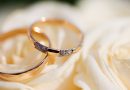 Deux alliances dorées posées sur une fleur claire, symbolisant un mariage et l’union civile