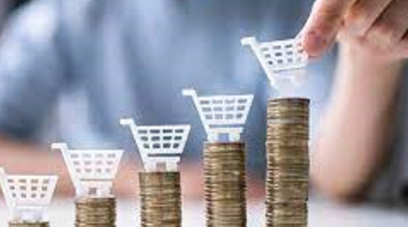 Main tenant un chariot de courses miniature posé sur des piles de pièces de monnaie de hauteurs croissantes, illustrant l’écart entre le travail fourni et le pouvoir d’achat réel