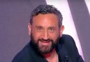Animateur de télévision barbu souriant sur un plateau de talk-show, éclairage de studio, ambiance médiatique professionnelle