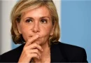 Femme politique assise lors d’une prise de parole officielle, le regard concentré, la main posée près du visage, dans un cadre institutionnel sobre