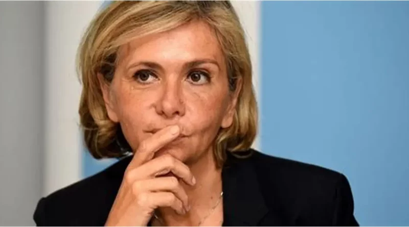 Femme politique assise lors d’une prise de parole officielle, le regard concentré, la main posée près du visage, dans un cadre institutionnel sobre