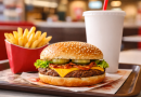Plateau de restauration rapide avec un hamburger, des frites et une boisson, servis dans un restaurant, sans logo ni marque visible.