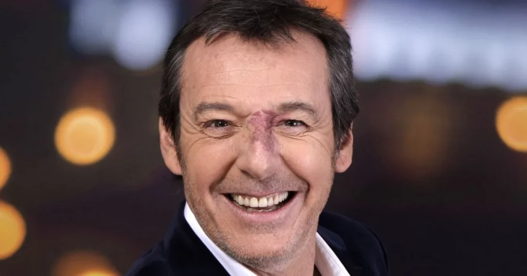 Animateur de télévision souriant en gros plan, éclairage studio, expression chaleureuse et naturelle.