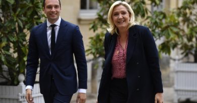 Deux responsables politiques marchant côte à côte dans une cour institutionnelle, souriants, vêtus de tenues formelles, illustrant la progression d’un courant politique dans l’opinion publique française.