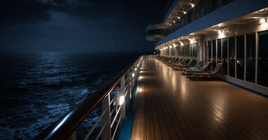 Pont désert d’un grand navire de croisière naviguant de nuit sur une mer sombre et calme, éclairé par quelques lumières blanches.