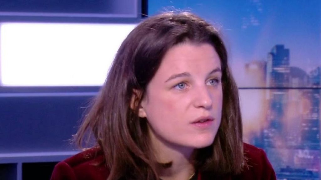 Chroniqueuse politique filmée en gros plan sur un plateau de télévision lors d’une émission d’actualité.