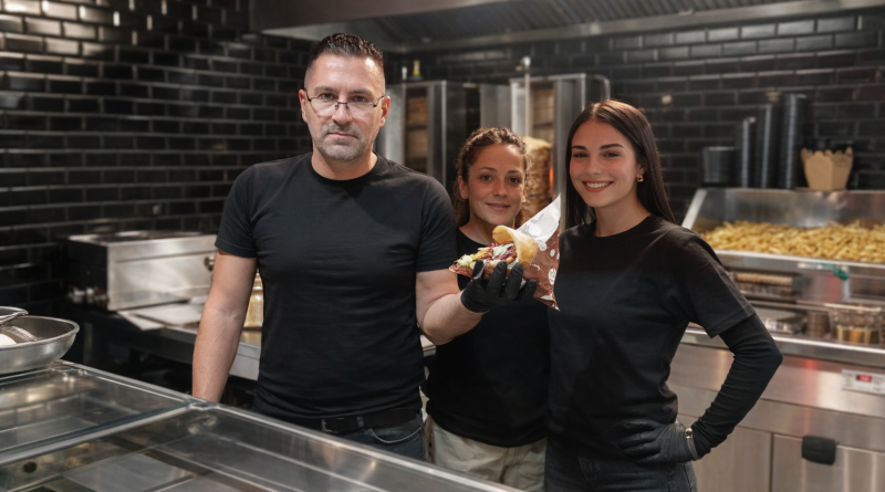 Équipe de restauration rapide présentant un kebab artisanal préparé sur place dans une cuisine professionnelle moderne.