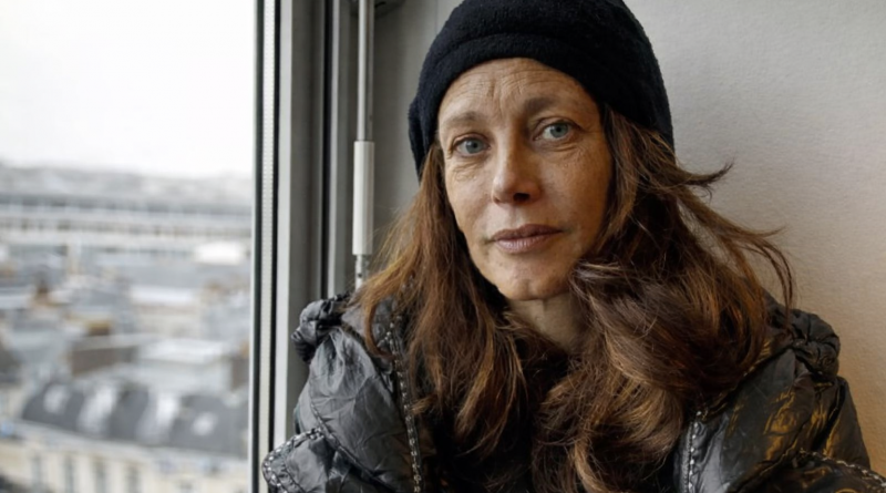 portrait d’une femme au regard marqué assise près d’une fenêtre après une période de grande précarité