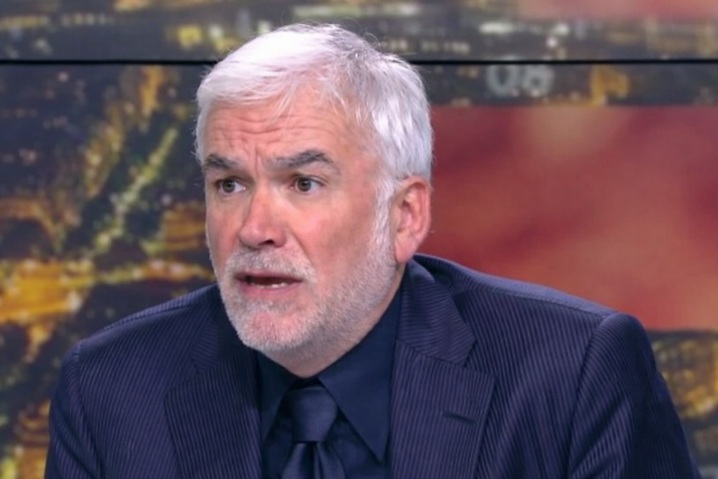 animateur de débat télévisé visiblement tendu en plein direct sur un plateau de télévision